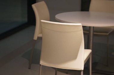 Odada beyaz sandalyeler ve masalar                               