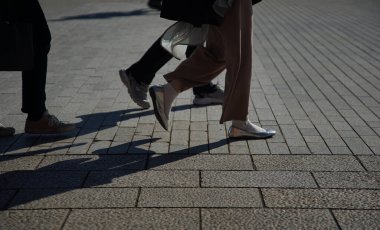 The person who walks the sidewalk of the stone pavement of the street of the town                               