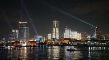 Japon Yokohama Limanı 'nda aydınlatılmış modern gökdelenlerin gece görüşü                              