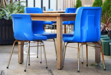 Açık kafe kare masa ve mavi sandalyeler.                               