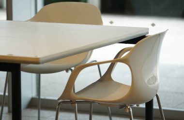 Restoranın penceresinin yanındaki beyaz masa ve sandalyeler.                               