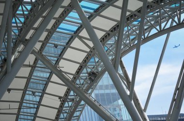 Modern bina çatısı çelik çerçeve ve gökyüzünde uçan uçak                               