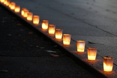 Geceleri bahçenin yolunu aydınlatan bir çok bardaktaki mum alevi.                               