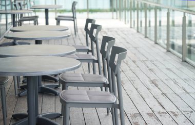 Güneşli bir günde kafe terasında masa ve sandalyeler                               
