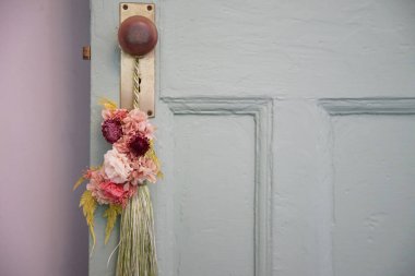 Flowers on the doorknob of the entrance door of the room                                clipart