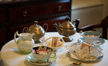 Çay saatinde çay fincanları ve çömlekler masanın üstünde.                               