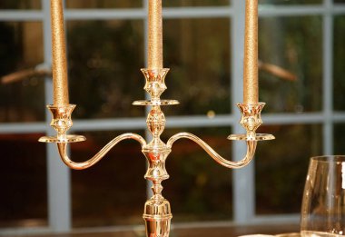 Altın metal mum, geceleri odanın penceresinin yanında durur.                               