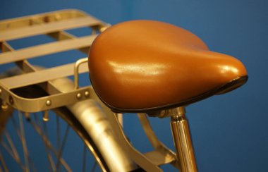 Bisikletin oturma yerinde kahverengi eyer var.                               