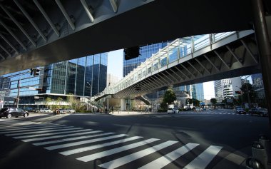 Japonya 'nın şehir merkezindeki kavşağın üzerindeki yaya köprüsünde çelik bina.                               