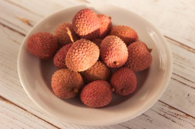 Beyaz bir tabakta olgun liçi meyveleri (Litchi chinensis)