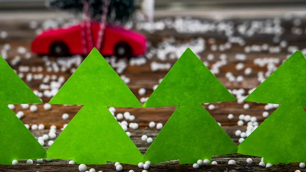 Yeşil Kağıt Ağaçlar Arkasında Noel Ağacı Olan Kırmızı Oyuncak Araba — Stok fotoğraf