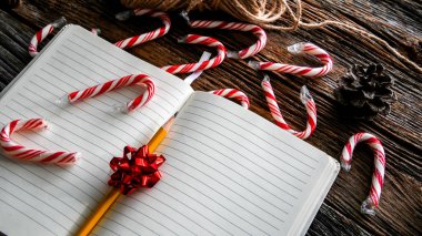 Kırsal ahşap masa üzerinde kalem ve noel süslemesi ile açık bir kitap