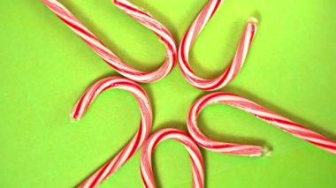 Kırmızı ve beyaz renkli şeker konisi yeşil kağıtta dönüyor