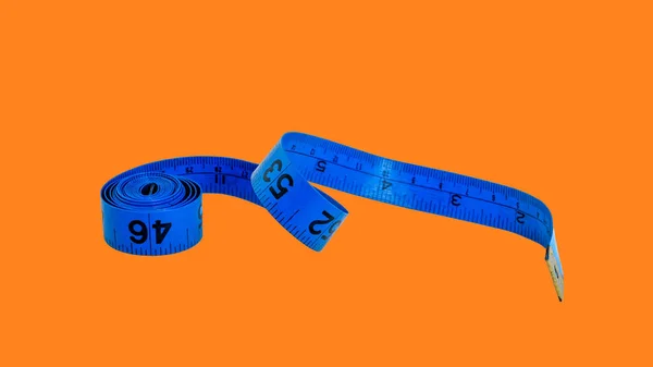 Soft tape measure in blue color isolated on  orange background