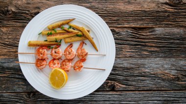 Yukarıdan beyaz tabakta bebek mısırı olan karideslerden uzak dur.