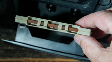 Hand is holting vintage casette near open boom box door