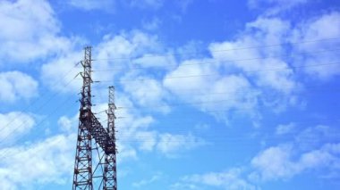 Elektrik kulesi ve mavi gökyüzünde hareket eden bulutlarla zaman aşımı