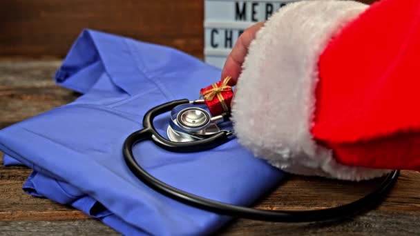 Santa Claus Adding Gift Blue Medical Shirt Stethoscope Table Turning — Stock Video