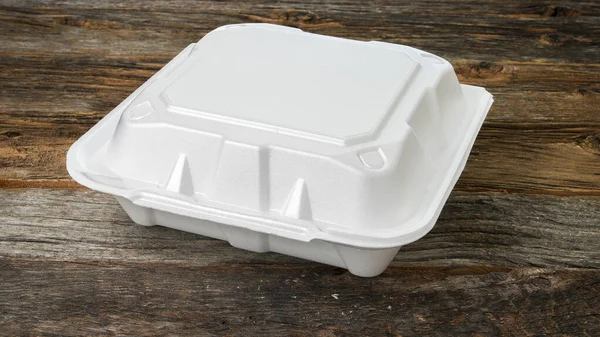 Styrofoam food delivery container on wooden rustic table