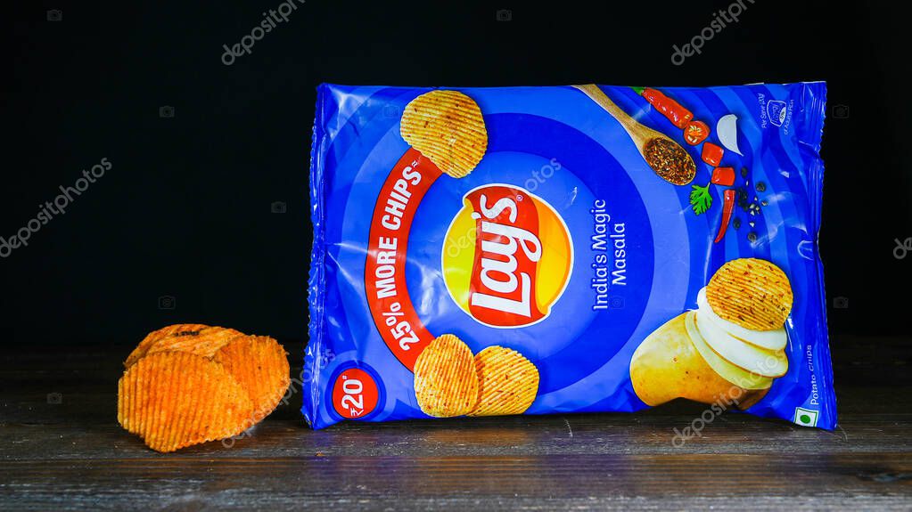 NORWALK, CT, USA - FEBRUARY 1, 2024: India's magic masala chips from Lays package on wooden table and black background