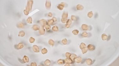 Bezelyeler yavaş çekimde kaseye düşüyorlar.