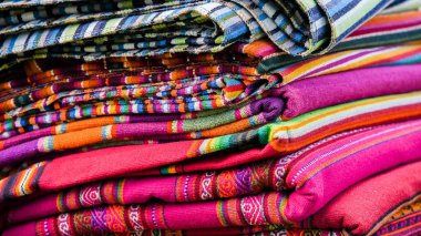 Renkli dokuma kumaşlar, canlı bir kültürel ortamda yerel bir pazardan çeşitli desenleri ve dokuları düzgün bir şekilde gösteriyor.