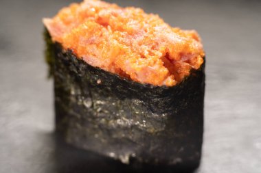 Gunkan Maki suşisi, deniz ürünleri, havyar ve baharatlı sos. Siyah üzerine izole edilmiş ton balıklı baharatlı Gunkan. Enfes Gunkan Sushi, kapat şunu.