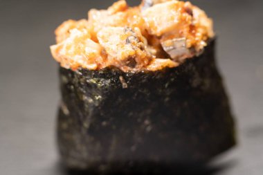 Siyah arka planda izole edilmiş deniz ürünleri ve baharatlı soslu Gunkan Maki suşisi. Nefis Gunkan suşisi. Japon yemeği, restoran menüsü