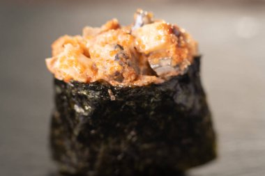 Gunkan Sushi 'yi kapatın. Gunkan Maki suşisi, deniz mahsulü ve baharatlı sos. Siyah arka planda nefis Gunkan suşisi. Japon yemekleri siyah arka planda izole edilmiş.