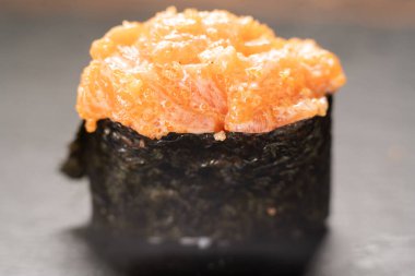 Gunkan Sushi 'yi kapatın. Gunkan Maki suşisi, deniz ürünleri, havyar ve baharatlı sos. Siyah arka planda nefis Gunkan suşisi. Japon yemekleri siyah arka planda izole edilmiş.