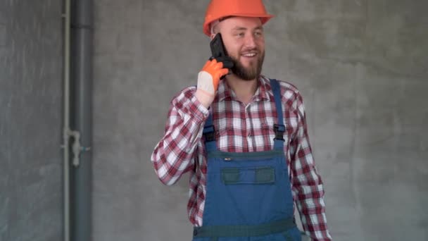 Счастливый Улыбающийся Бородатый Работник Строитель Звонящий Смартфоне Комнате Фоном Профессия — стоковое видео