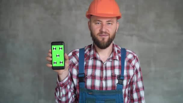 Usługi Budowlane Mężczyzna Budowlaniec Demonstrujący Pusty Smartfon Uśmiechnięty Mężczyzna Bezpiecznym — Wideo stockowe
