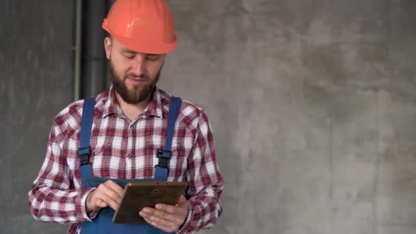 Szczęśliwy Budowniczy Lub Mechanik Pracujący Tablecie Szarym Tle Ściany Foreman — Wideo stockowe