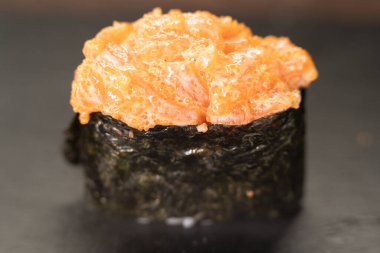 Gunkan Sushi 'yi kapatın. Gunkan Maki suşisi, deniz ürünleri, havyar ve baharatlı sos. Siyah arka planda nefis Gunkan suşisi. Japon yemekleri siyah arka planda izole edilmiş.