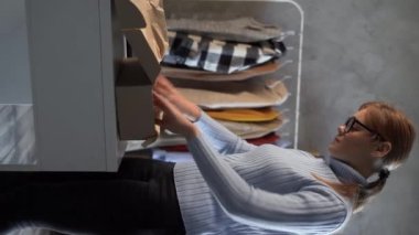 Küçük işletmeler kuran KOBİ 'li kadın girişimciler, kutuların paketlenmesi, müşterilere satılması, giysi satışı, çevrimiçi sme iş fikirleri konsepti gibi siparişleri çevrimiçi olarak hazırlıyorlar. Dikey video