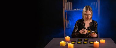 Falcı kadın tarot kartlarıyla geleceği okuyor. Ayin mumlarının yanması, ruh çağırma, duman. Pankart, metin için boşluk