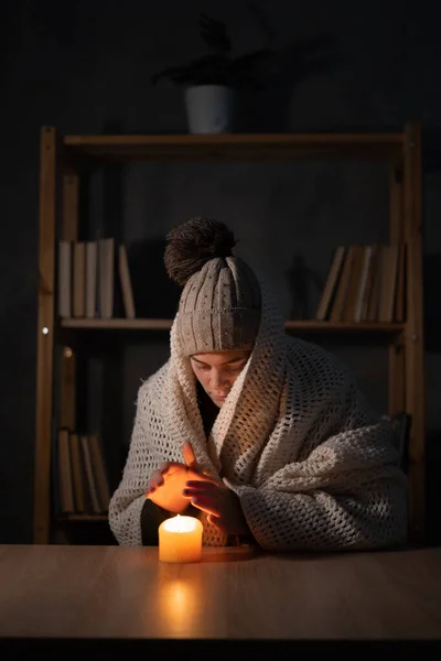 Woman suffers in no heating and no electricity during an energy crisis in Europe causing blackouts. power outage, blackout, load shedding or energy crisis, concept image.