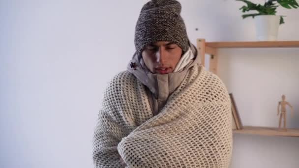 風邪をひいた若い男が風邪をひいた気分だ毛布で覆われたインフルエンザの症状 家で凍える病気の男 暖房の問題はないと熱温度の概念 — ストック動画