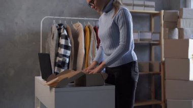 Küçük işletmeler kuran KOBİ 'li kadın girişimciler, kutuların paketlenmesi, müşterilere satılması, giysi satışı, çevrimiçi sme iş fikirleri kavramı için çevrimiçi siparişler hazırlıyorlar.
