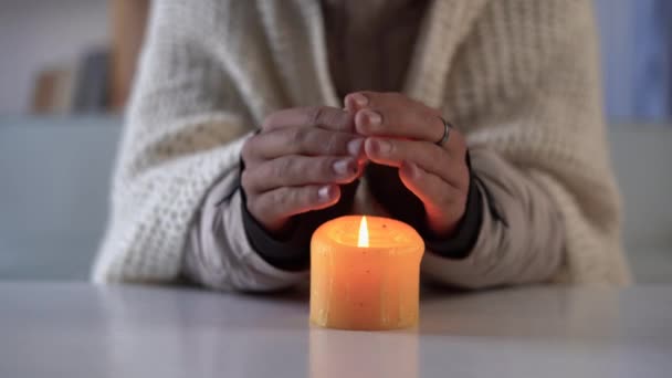 紧紧地握住人类的手 会被炽热的蜡烛加热 冬天在家里不能取暖的概念 停电或能源危机 — 图库视频影像