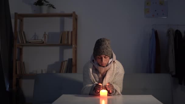 Замерзающий Молодой Человек Зимней Одежде Греет Руки Свечах Энергетические Отключения — стоковое видео