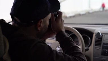 Özel dedektif arabada oturuyor. Kamera ve içeriden görüntü alıyor.