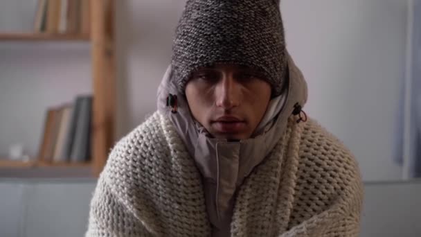暖かい服を着た男が家の中で寒さを感じている 家庭用暖房トラブルコンセプト — ストック動画