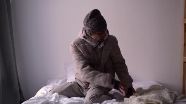 怒っている若い男暖かい服を自宅で寒さを感じる服を着た 中央暖房 冬のトラブル 寝室の冷凍男 — ストック動画