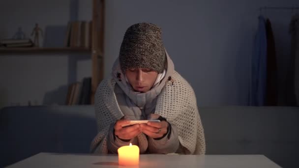 暖房や電気のシャットダウン 若い男は彼の家で寒さを感じて 負荷を流す エネルギー危機の概念 — ストック動画