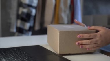 Başlangıçta küçük işletme KOBİ 'si ürün nakliyat kutusu hazırlıyordu. Genç bir kadın teslimat paketini barkodla etiketliyordu. Çevrimiçi satış, e-ticaret, nakliye konsepti