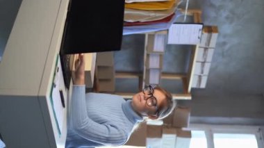 Küçük işletme KOBİ sahibi dizüstü bilgisayarda ürün paketleme sipariş kutusu kullanıyor. Genç bir kadın barkodlu teslimat paketini etiketliyor. Çevrimiçi satış, e-ticaret, nakliye konsepti. Dikey video