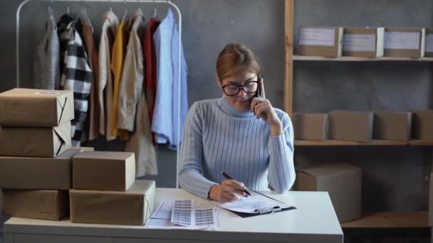 電話で顧客からの注文を確認する女性オンライン販売業者 — ストック動画