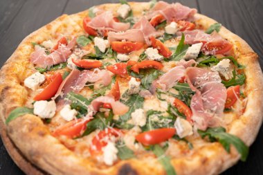 Prosciutto, roka, domates ve parmesanlı pizza. İtalyan mutfağı. Kapat.