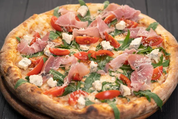 Prosciutto, domates ve ahşap tabakta roka ile pizza. Boşluğu kopyala